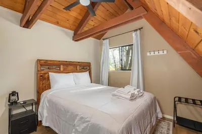 a bedroom with a bed with white sheets and a window at The Play Pen in Arnold