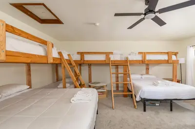 a bedroom with two bunk beds and a ceiling fan at The Play Pen in Arnold