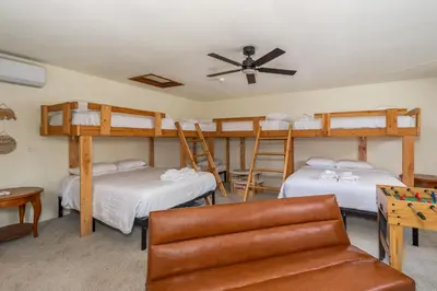 a bedroom with two bunk beds and a couch at The Play Pen in Arnold