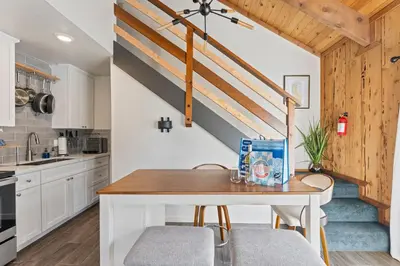 a kitchen with white cabinets and a wooden table at HNC0691 - Tramway Treat home in Stateline