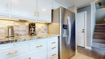 a kitchen with white cabinets and a stainless steel refrigerator at Snowcreek V #888 condo in Mammoth Lakes