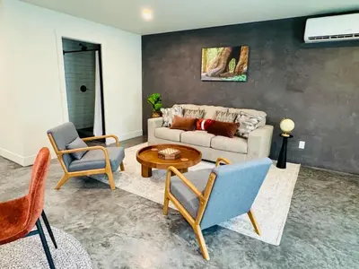 a living room with a couch and a table and chairs at 2 Homes by the River in Three Rivers