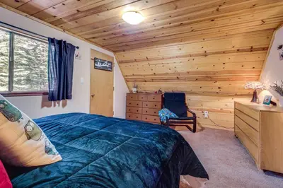 a bedroom with a bed and a wooden wall at Near Slopes, Donner Lake and Trails! Woodsy Retreat in Truckee