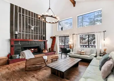 a living room with a fireplace and a table at 3390 Pine Hill Road home in South Lake Tahoe
