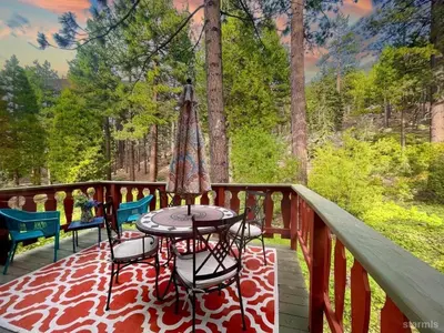 a table and chairs on a deck with an umbrella at 3390 Pine Hill Road home in South Lake Tahoe