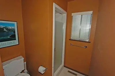 a bathroom with a toilet and a glass shower door at 584 Alpine Drive home in South Lake Tahoe