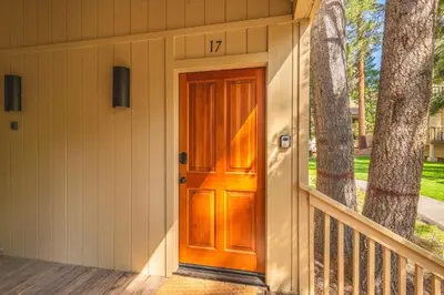 a wooden front door of a house with a tree at Kings Beach Luxe in Kings Beach