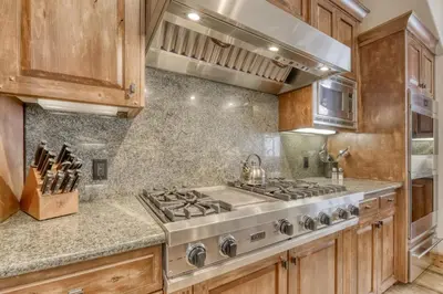 a kitchen with a stove top oven and wooden cabinets at Silverfox at Northstar in Truckee