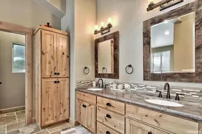 a bathroom with two sinks and two mirrors at 539 Wintoon Drive home in South Lake Tahoe