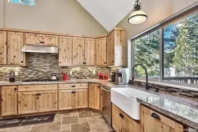 a kitchen with wooden cabinets and a large window at 539 Wintoon Drive home in South Lake Tahoe