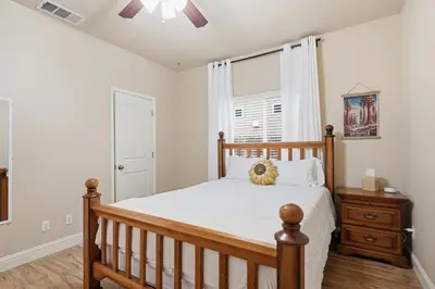 a bedroom with a wooden bed and a window at Casa Cortez in Visalia