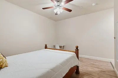 a bedroom with a bed with a ceiling fan at Casa Cortez in Visalia