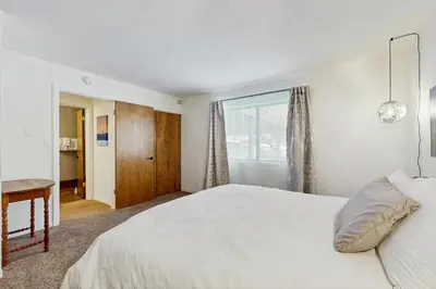 a white bedroom with a bed and a window at Pine Hill Hideaway in South Lake Tahoe