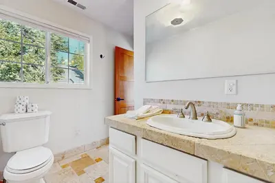 a white bathroom with a toilet and a sink at Lakeview Getaway at Rubicon Bay in Tahoma