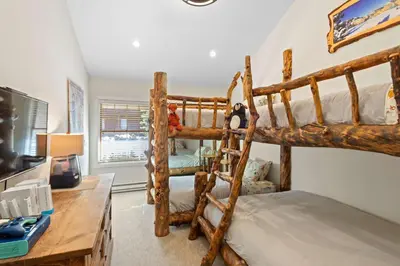 a bedroom with two bunk beds and a desk at Luxury 3BR 3BA Condo Steps from Canyon Lodge Lift in Mammoth Lakes