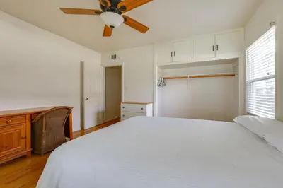 a bedroom with a white bed and a ceiling fan at Hot Tub, Patio and Outdoor Games at Visalia Home in Visalia