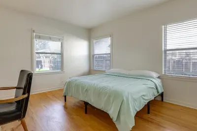 a white bedroom with a bed and two windows at Hot Tub, Patio and Outdoor Games at Visalia Home in Visalia