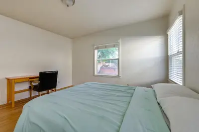 a bedroom with a bed and a desk and a window at Hot Tub, Patio and Outdoor Games at Visalia Home in Visalia