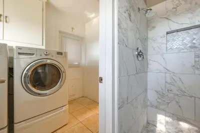 a washer and dryer in a white bathroom at Hot Tub, Patio and Outdoor Games at Visalia Home in Visalia