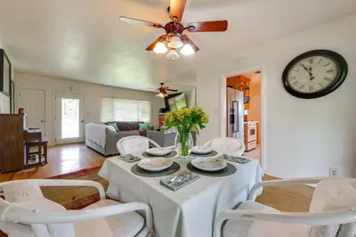 a living room with a table and a clock on the wall at Hot Tub, Patio and Outdoor Games at Visalia Home in Visalia