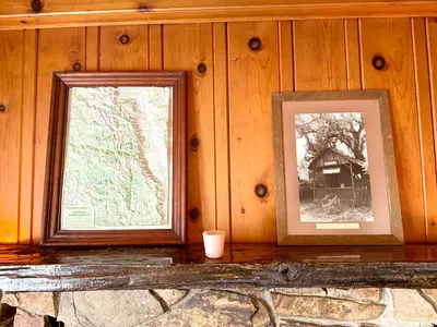 two framed photographs on a wooden wall with a bench at Cozy Farm House with River access in Three Rivers