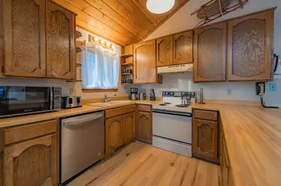 a kitchen with wooden cabinets and a stove top oven at Oglala Little Lodge - For 4 in South Lake Tahoe
