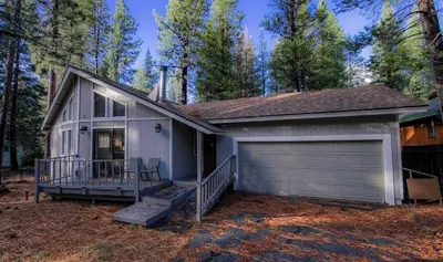 a house with a garage in the woods at Oglala Little Lodge - For 4 in South Lake Tahoe