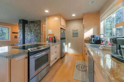 a large kitchen with wooden counters and a stove top oven at Bakersfield Basecamp - Meyers Escape in South Lake Tahoe