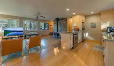 a kitchen with wooden floors and a living room at Bakersfield Basecamp - Meyers Escape in South Lake Tahoe