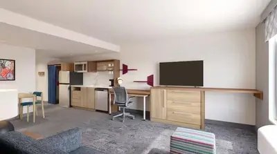 a living room with a kitchen and a desk with a television at Home2 Suites By Hilton Carson City in Carson City