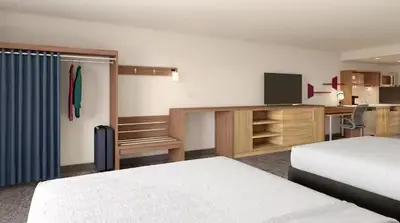 a hotel room with a bed and a desk with a television at Home2 Suites By Hilton Carson City in Carson City