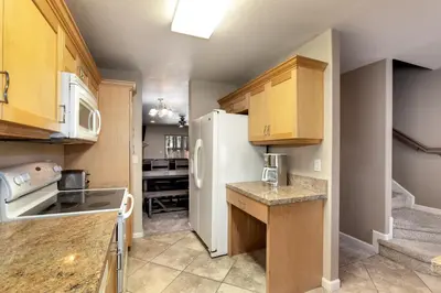 a kitchen with wooden cabinets and a white refrigerator at Meadow Chalet townhouse in South Lake Tahoe