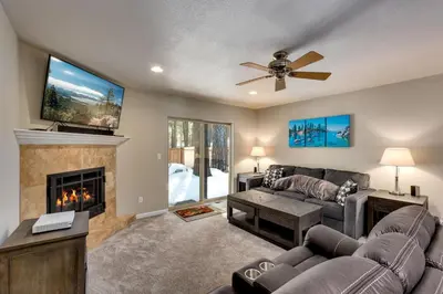 a living room with a couch and a fireplace at Meadow Chalet townhouse in South Lake Tahoe