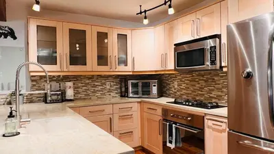 a kitchen with wooden cabinets and a stainless steel refrigerator at Cozy Cabin and Modern Stay in Arnold Near Bear Valley in Arnold