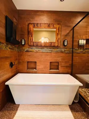 a white bath tub in a bathroom with wooden walls at Cozy Cabin and Modern Stay in Arnold Near Bear Valley in Arnold