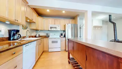 a large kitchen with wooden cabinets and white appliances at Western Slopes Villas #7 condo in Mammoth Lakes