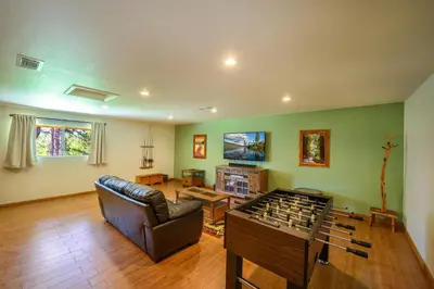 a living room with a leather couch and a table at Blue Bird Ranch in Oakhurst
