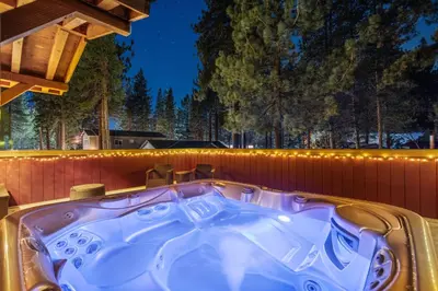 a jacuzzi tub on the back of a house at Tahoe Cabin - Hot Tub, Fire Pit, Pool Table, minutes from Heavenly in South Lake Tahoe