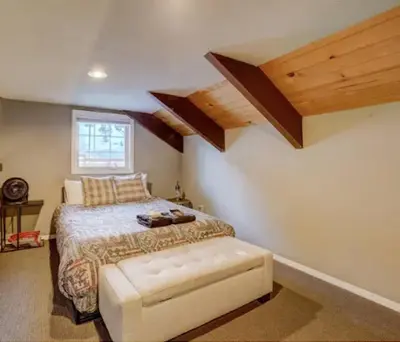 a bedroom with a bed and a window and wooden ceilings at Tramway near Heavenly/ Dogs OK/ New Heating & Air in Stateline