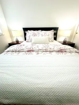 a bedroom with a large white bed with flowers on it at Tranquil Getaway in Fresno