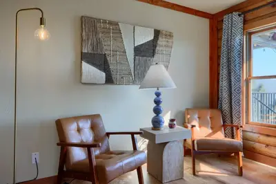 a living room with two chairs and a lamp at Sierra Mountain View Retreat in Coarsegold