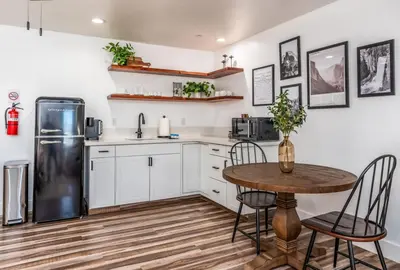 a kitchen with a table and a refrigerator at The Four Daughters Inn in Oakhurst