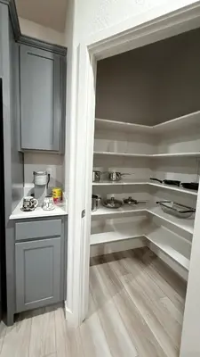 a kitchen with gray and white cabinets and wooden floors at New Holiday Retreat in Merced in Merced