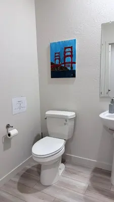 a bathroom with a toilet and a sink at New Holiday Retreat in Merced in Merced