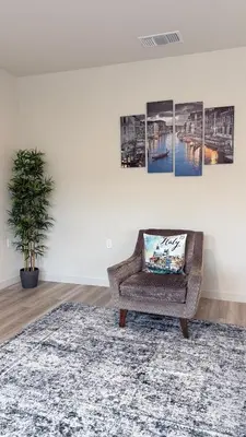 a living room with a chair and a rug at New Holiday Retreat in Merced in Merced