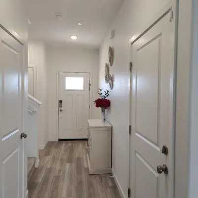 a hallway with a white door and a vase of flowers at The Orchid house !! Your home away from home Gateway to Yosemite & UC Merced this for a Room in Merced