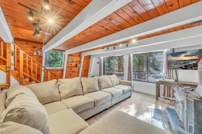a living room with a couch and a large window at Cozy Cabin- Large Deck , Near the Slopes in Homewood