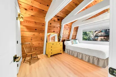 a bedroom with a bed and a window at Cozy Cabin- Large Deck , Near the Slopes in Homewood