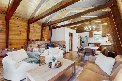 a living room with white furniture and a table at Charming Cabin in South Lake Tahoe