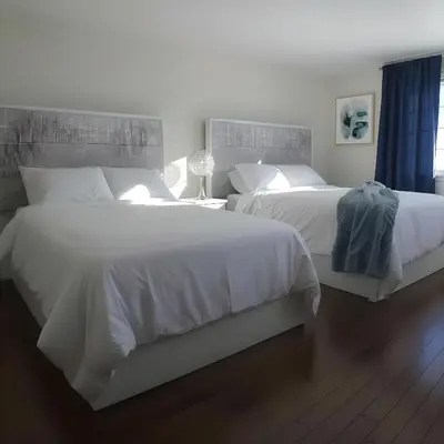 two beds in a hotel room with white sheets at PINECREST MAMMOTH LAKES in Mammoth Lakes